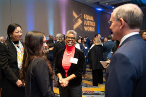 Photo of Verna Williams speaking with a group of event attendees and community supporters at the pre-event reception for the 2023 Scales of Justice.