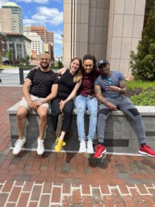 Photo DiNesha Rucker and the Homeless Youth Initiative Team at HPRP sitting together and smiling
