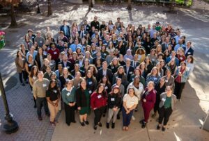 Group photo of 2025 Fellow attendees of Leadership Development Training standing outside and smiling together