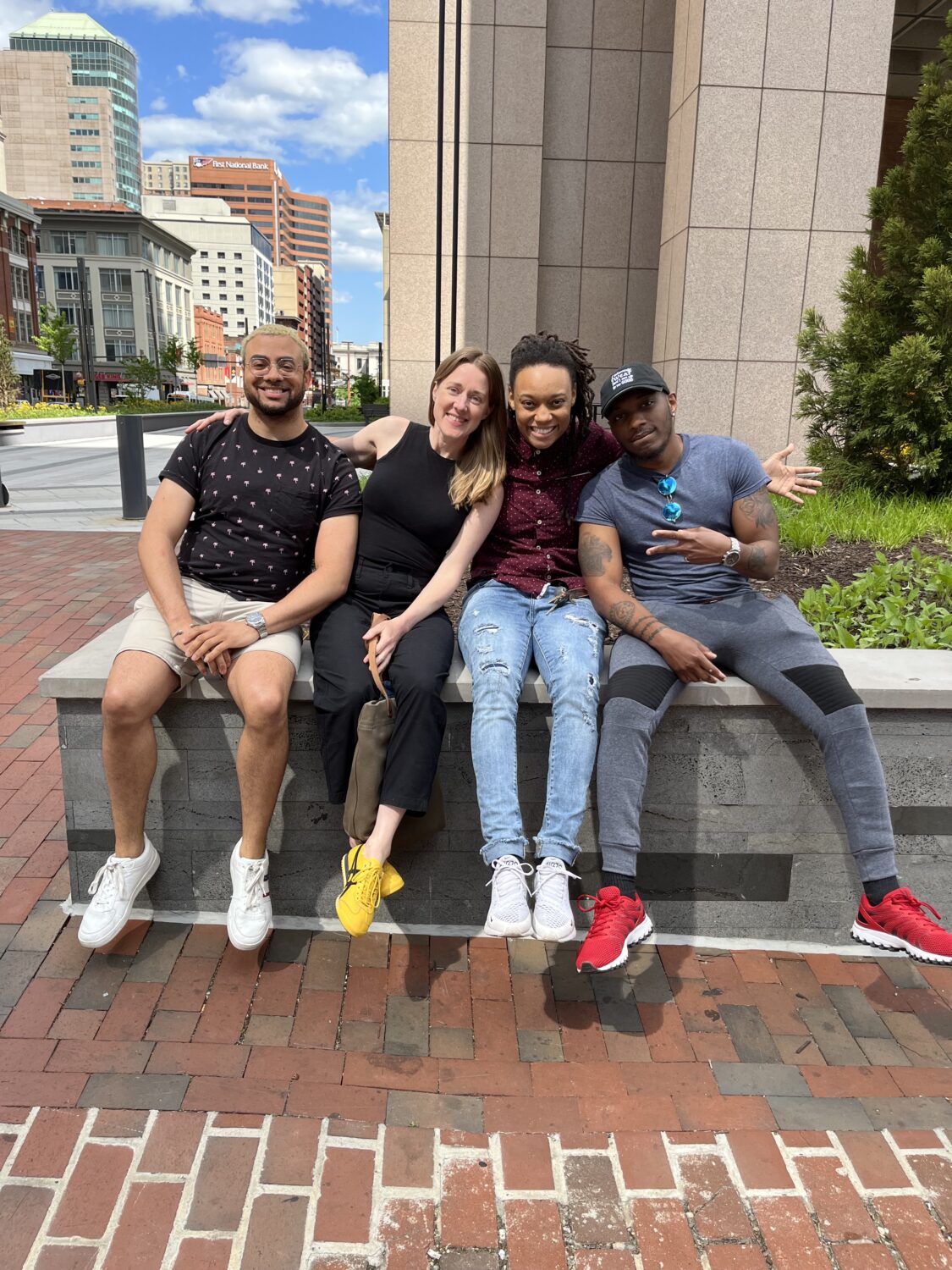 Photo DiNesha Rucker and the Homeless Youth Initiative Team at HPRP sitting together and smiling