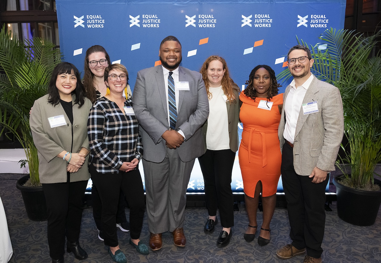 Members of the Alumni Advisory Council stand smiling together by the step-and-repeat at the welcome reception for LDT 2025